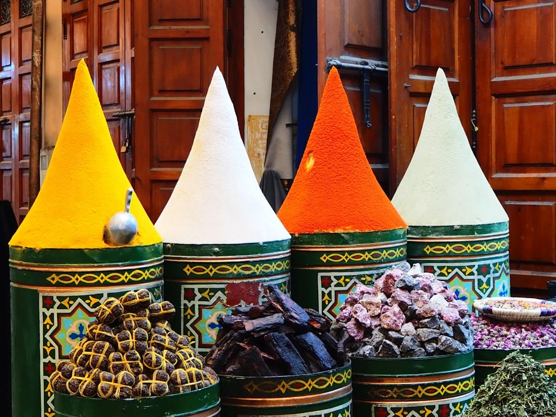 Coni di spezie colorate su fusti decorati in un souk